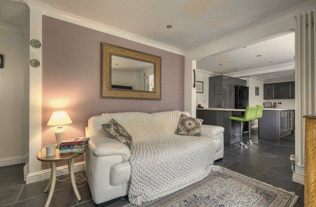 A sitting room with a glowing lamp beside a sofa and cushions